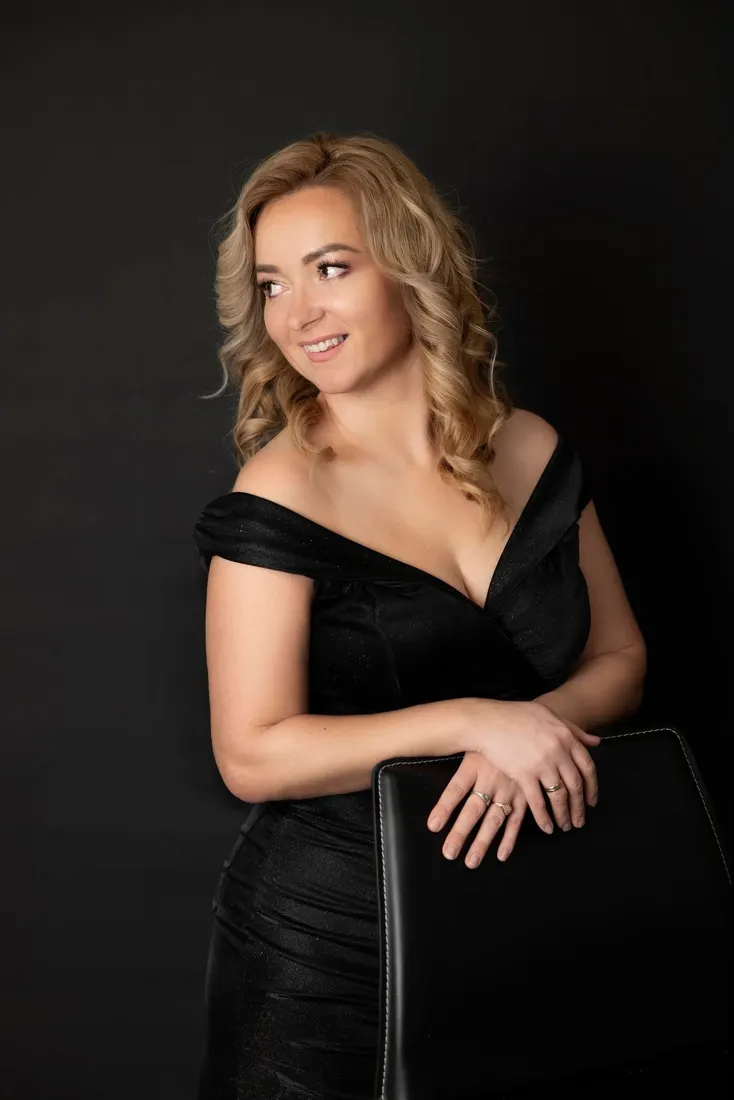 Portret biznesowy kobiety w różowej marynarce na ciemnym tle